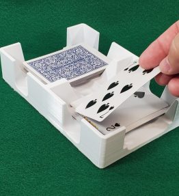 Hand placing card in white card caddy on green felt