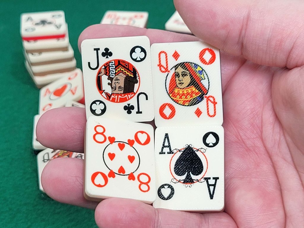 Hand holding 4 poker playing card tiles