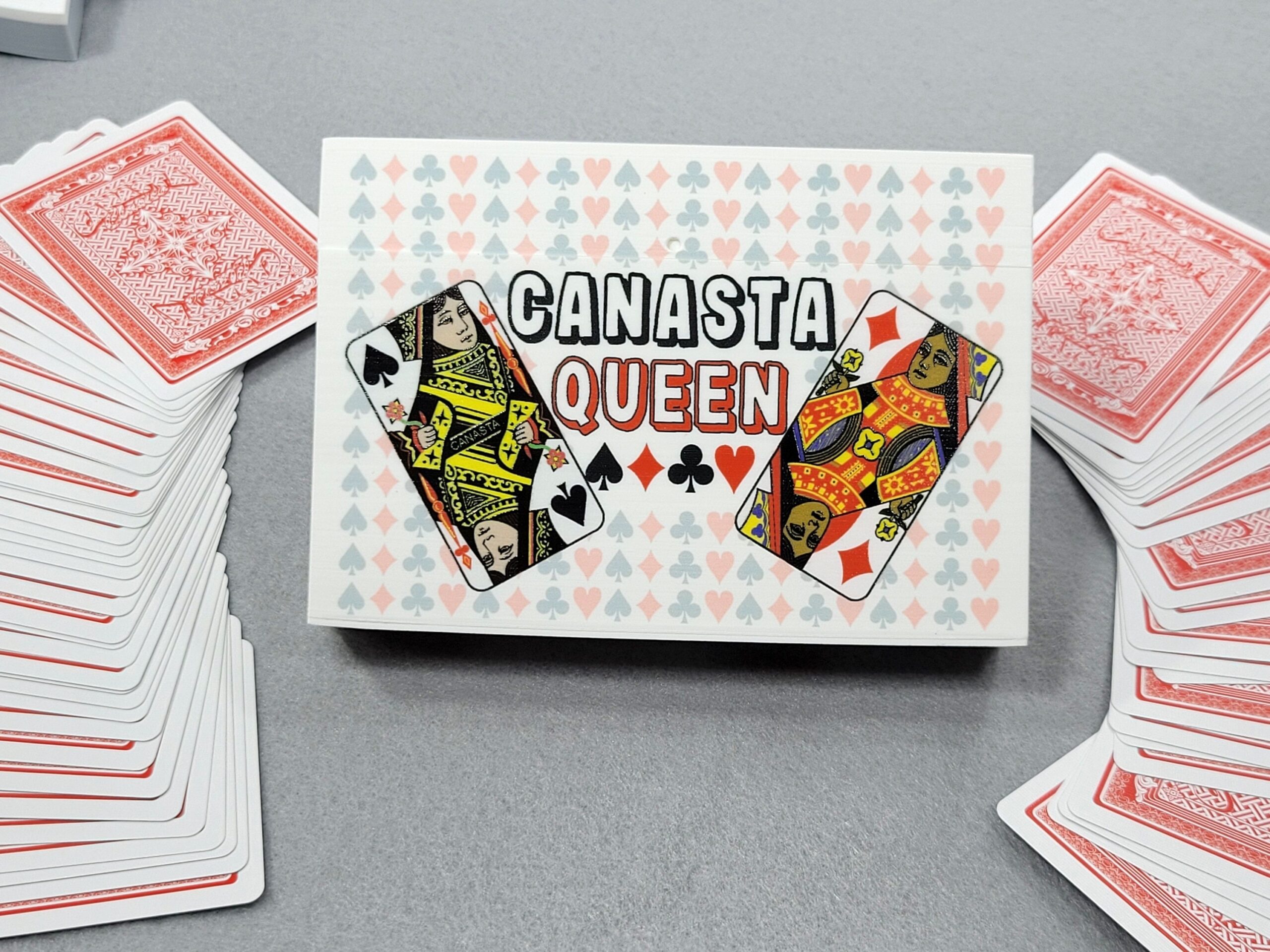 Canasta Queen Playing Card Box that features 4 queens from a deck of cards with a backdrop of pips (hearts, clubs, diamonds and spades)